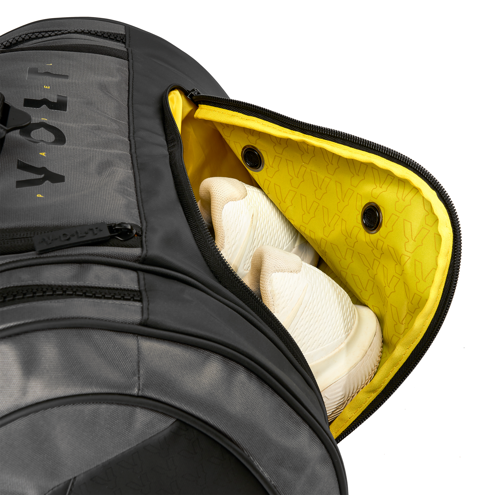 Volt’s grey XL padel bag with the shoe compartment open, ventilated yellow lining, and white sneakers inside.