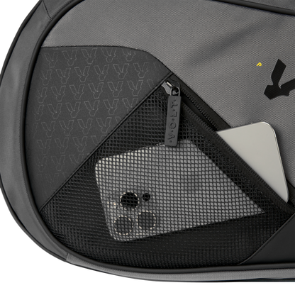 Close-up of Volt’s grey XL padel bag showing a black mesh pocket with a smartphone and a silver laptop inside.