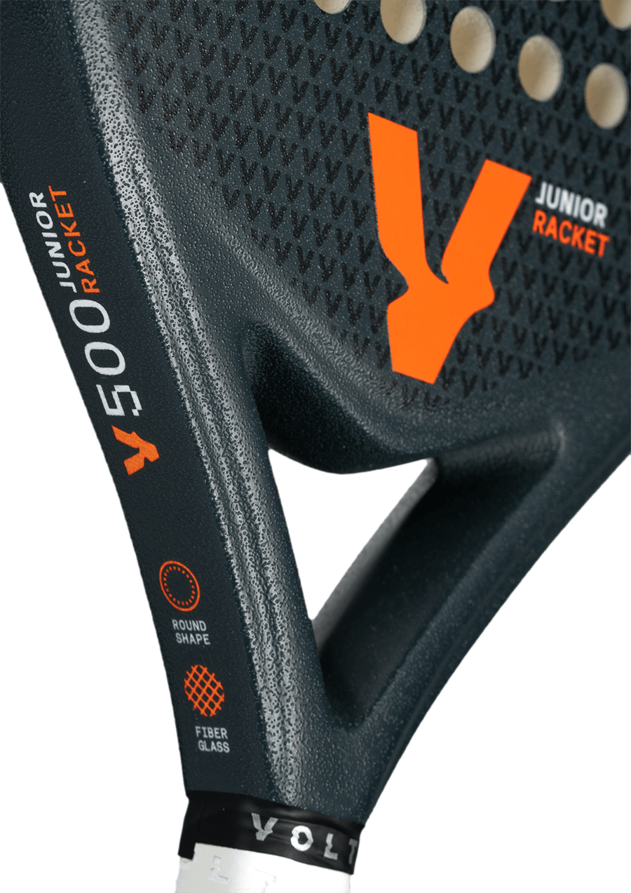 Close-up of the Volt 500 Junior V4 padel racket, focusing on the orange logo and 'Junior Racket' branding on the textured surface.