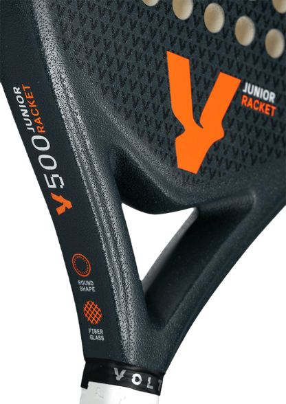 Close-up of the Volt 500 Junior V4 padel racket, focusing on the orange logo and 'Junior Racket' branding on the textured surface.
